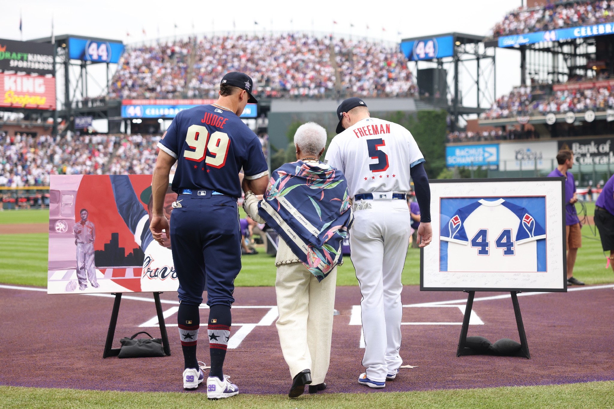 Aaron Judge and Freddie Freeman escorting Hank Aaron's widow during the MLB All-Star game tribute with custom framed memorabilia