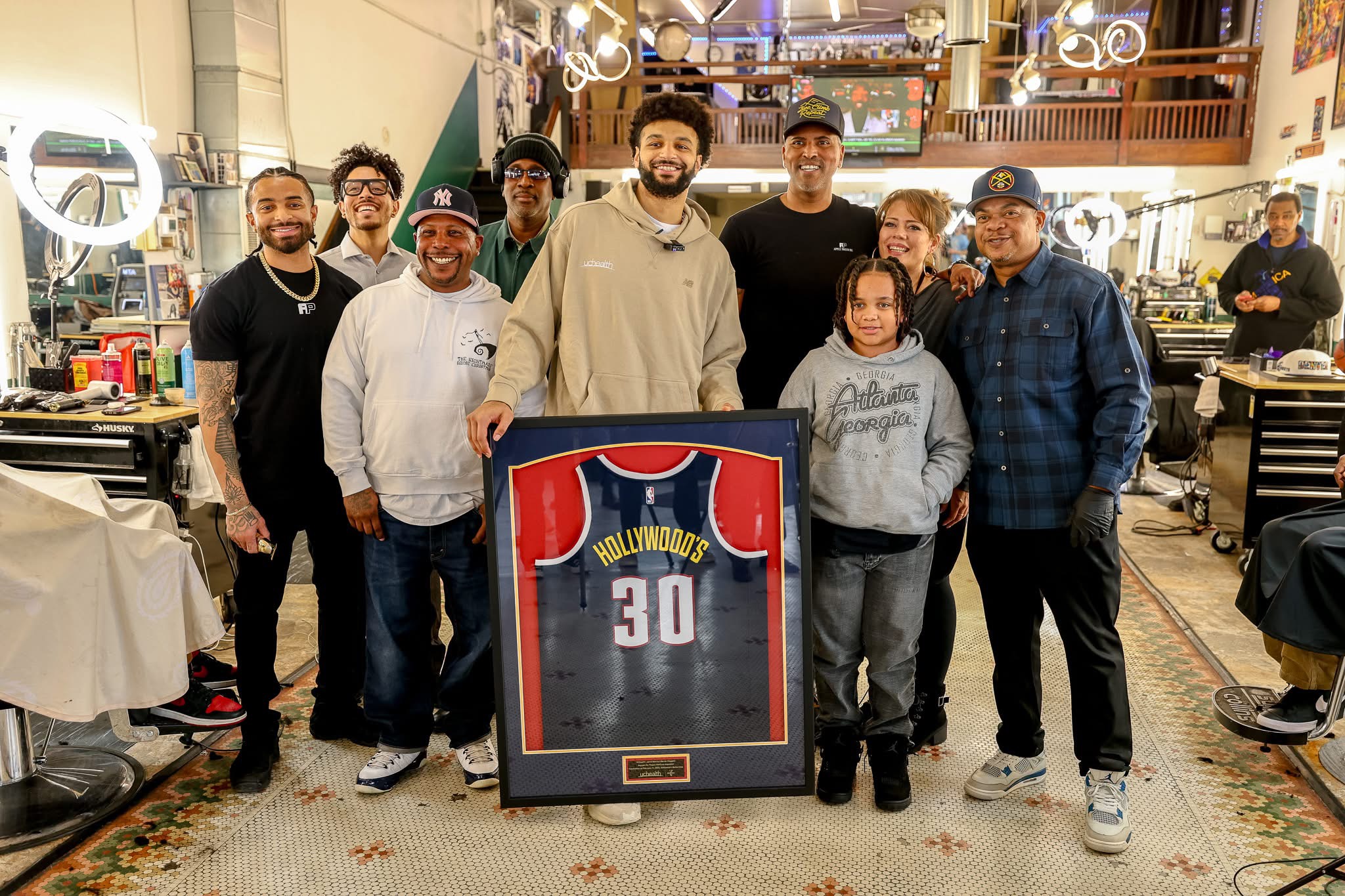 Denver Nuggets player, Jamal Murray, with family and custom framed basketball jersey