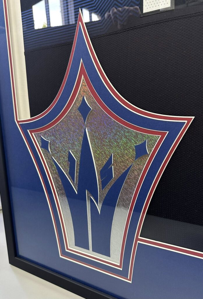 Custom metallic logo mat cut for a framed sports jersey display