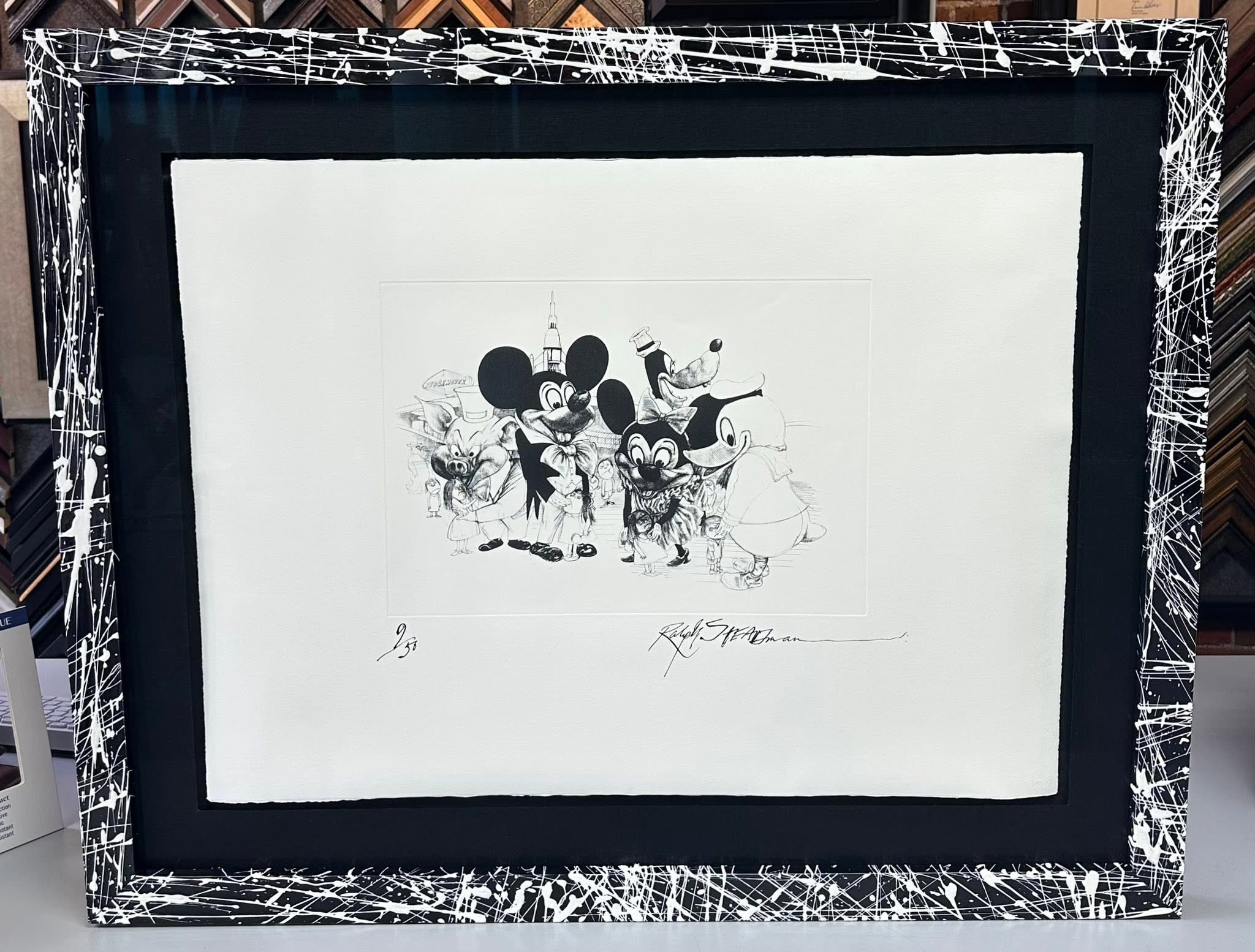 Custom framed Disney artwork with black matting and black splatter frame