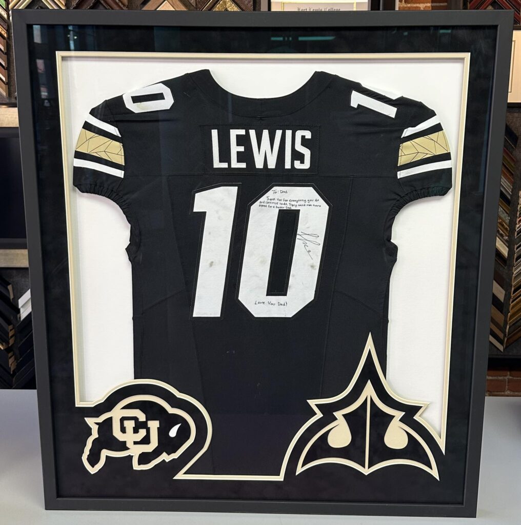 Custom framed Colorado Buffaloes football jersey with personalized inscription and sports memorabilia display