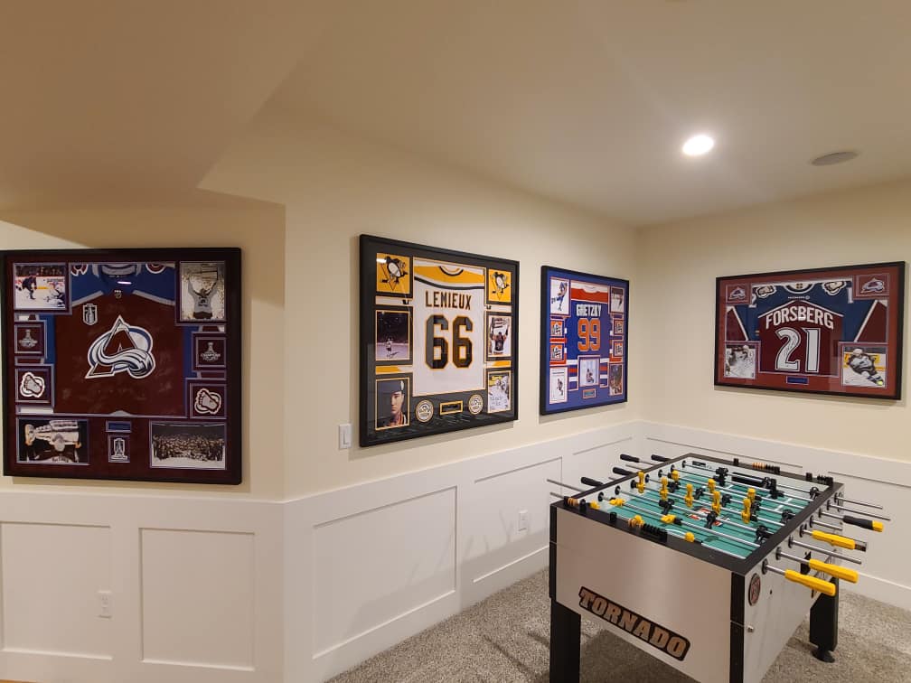 Custom framed Colorado Avalanche, Mario Lemieux, Wayne Gretzky and Peter Forsberg jerseys in a home game room