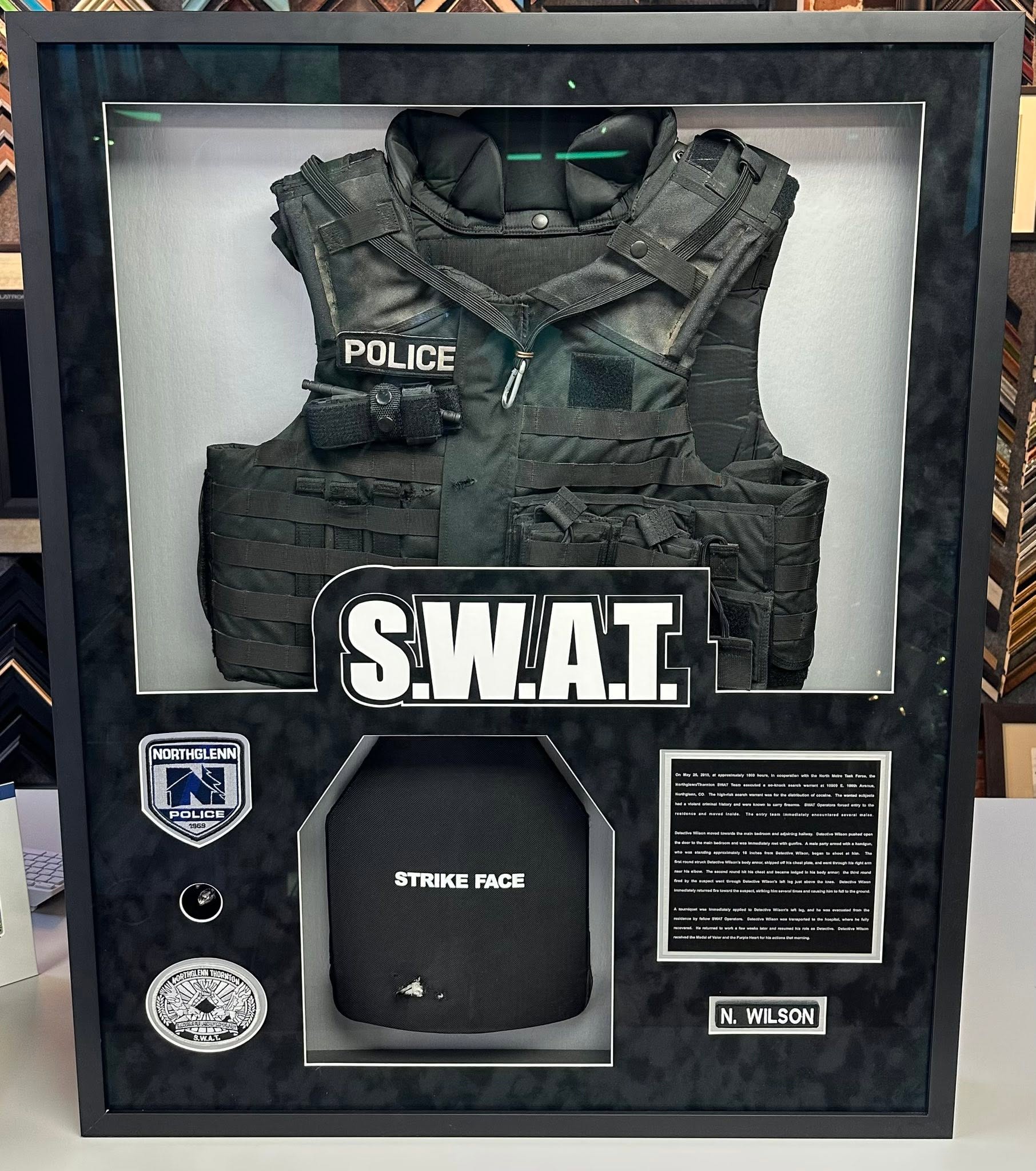 Custom law enforcement shadowbox display featuring SWAT tactical vest and service memorabilia