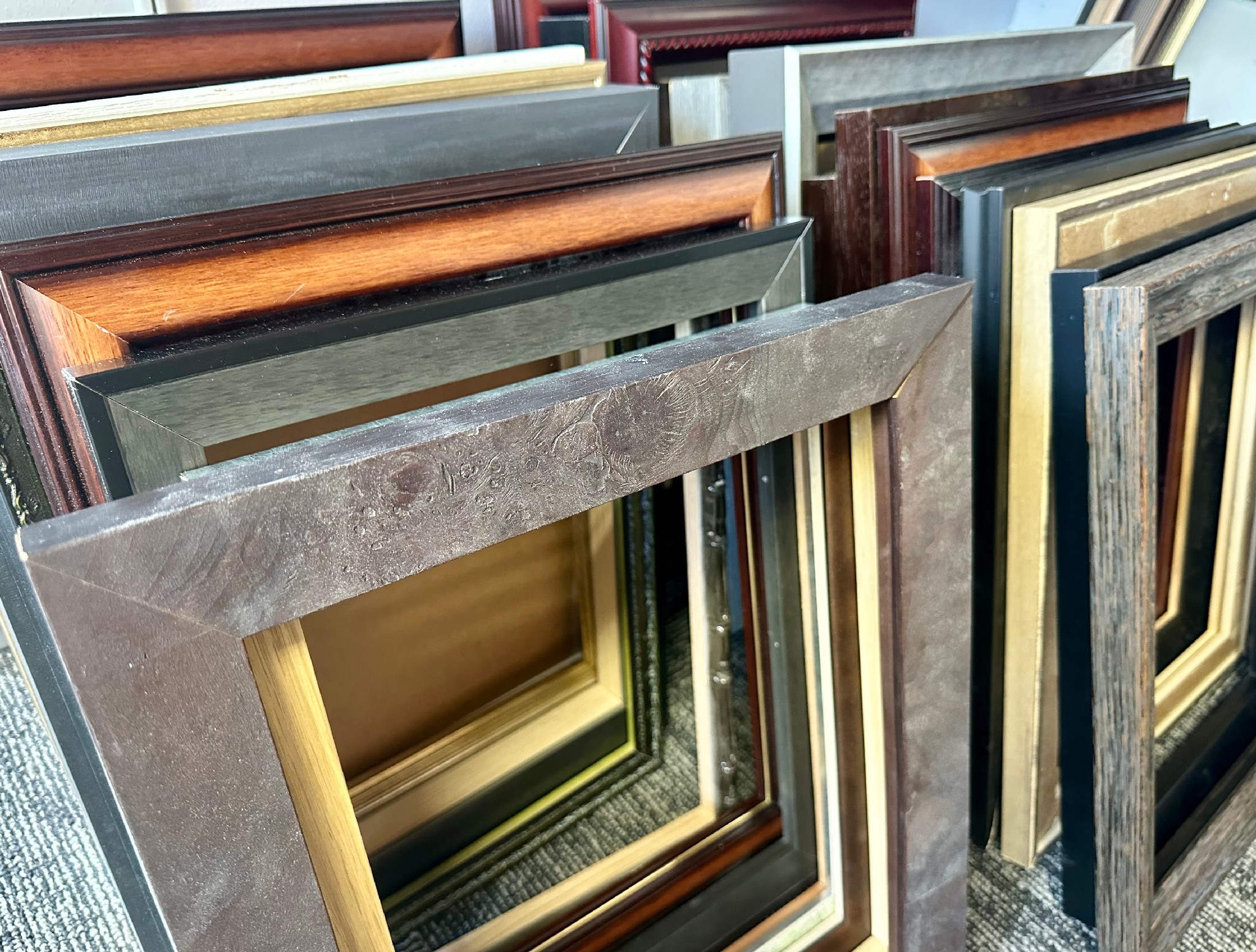Wide selection of custom picture frame moulding samples in wood, metal and contemporary finishes at our custom framing showroom